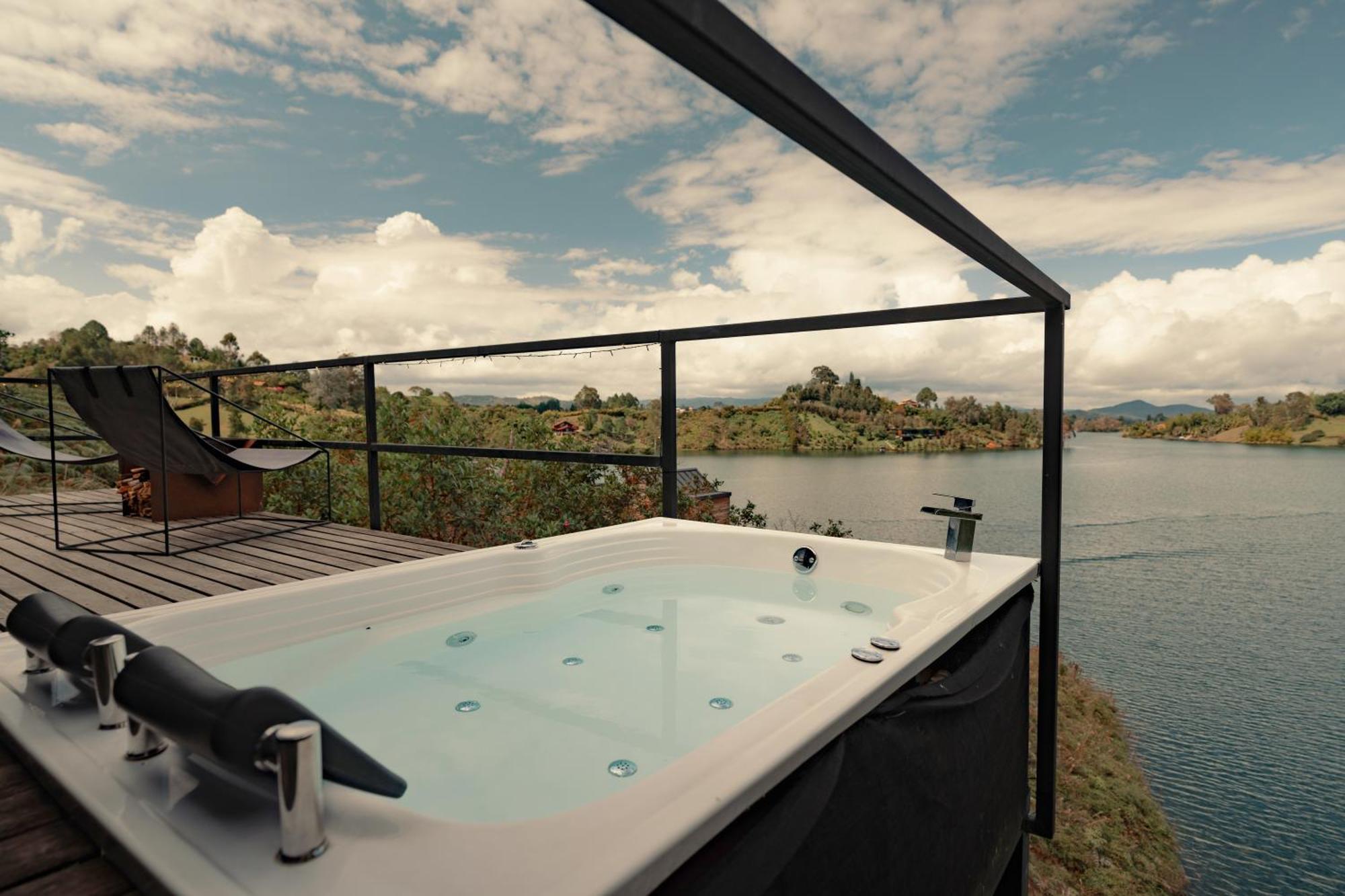 The Boato Hotel غواتابيه المظهر الخارجي الصورة A hot tub with a lake view